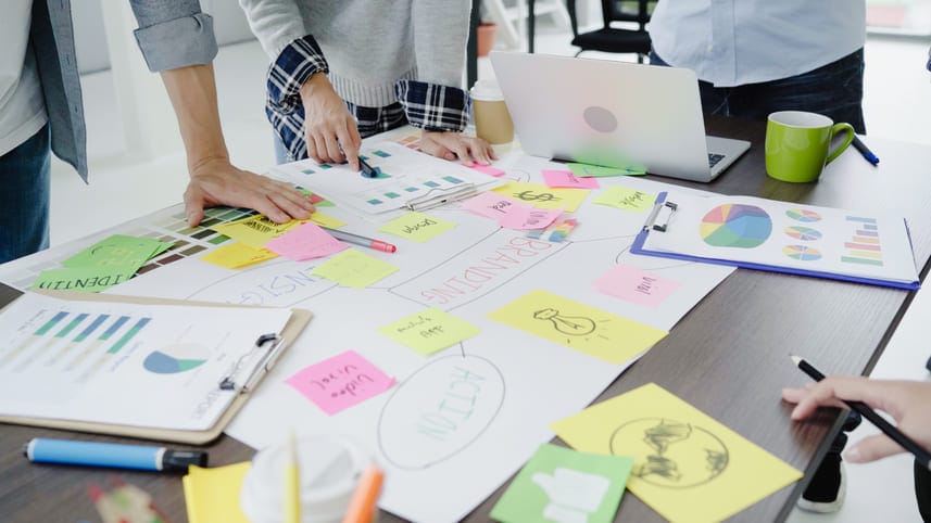 Planejamento do inbound marketing é uma agência, com várias pessoas em uma mesa cheia de post-its